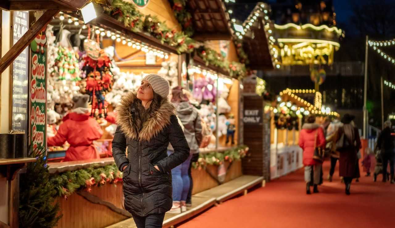 Donna che guarda le bancarelle dei mercatini natalizi